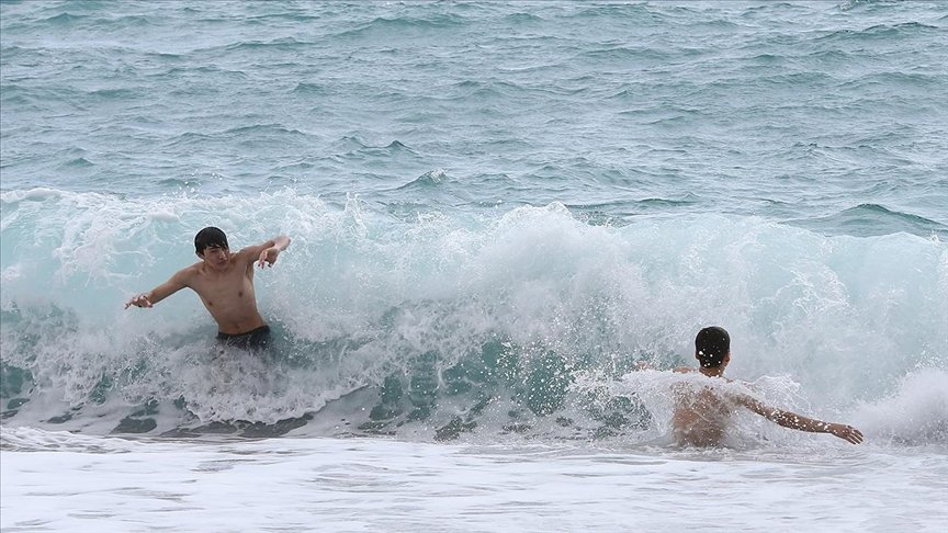 Antalya’da yabancı turistler dalgalara rağmen denize girdi