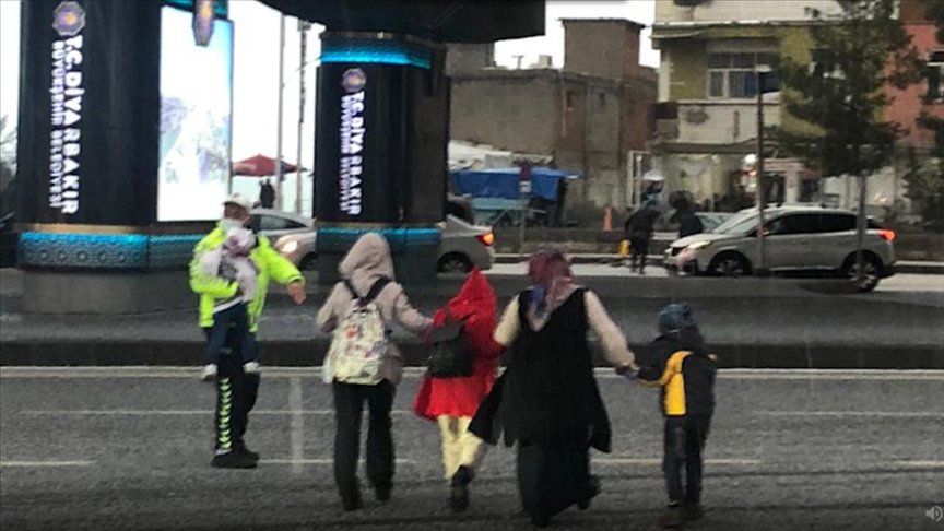 Diyarbakır’da doluya yakalanan anne ve çocukları trafik polisinin yardımıyla yolun karşısına geçti
